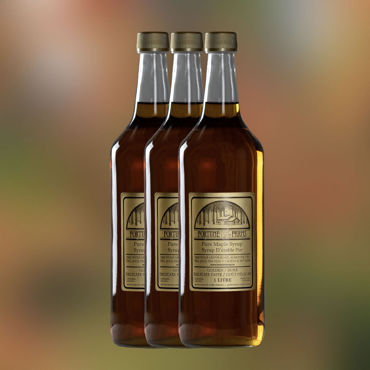 A photo of 3 glass bottles of maple syrup